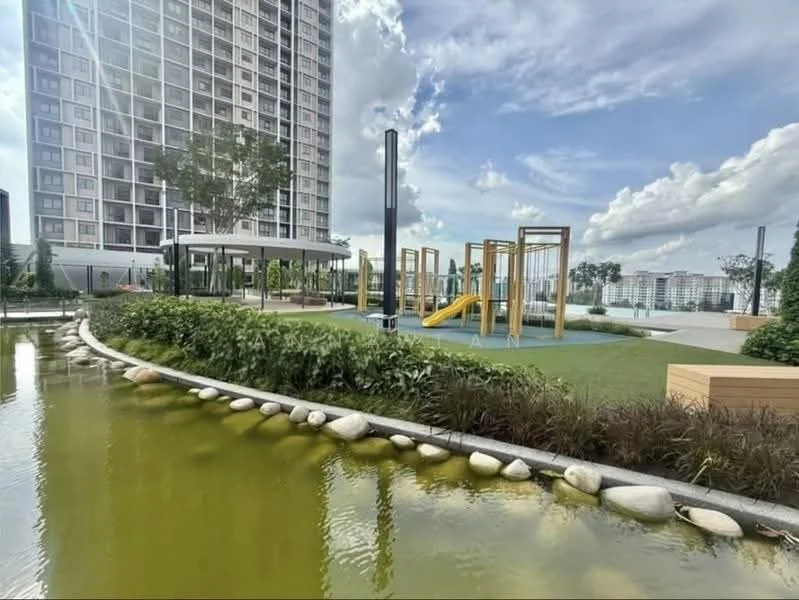 Exterior type: high-rise condominium; features: children's playground with slides and climbing structures, manicured lawn, landscaped garden with shrubs, pond with green water, stone-paved walkway, outdoor seating area, surrounding greenery, tall residential building in background; style: modern.