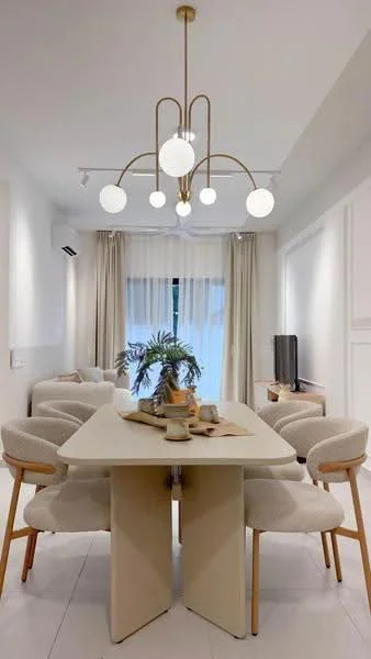 Dining features: round dining table, upholstered dining chairs, gold chandelier with spherical bulbs, floor-to-ceiling windows, sheer curtains, light wood flooring, wall-mounted TV, decorative plant on table, neutral wall color, built-in cabinetry, sofa in light fabric; style: modern.