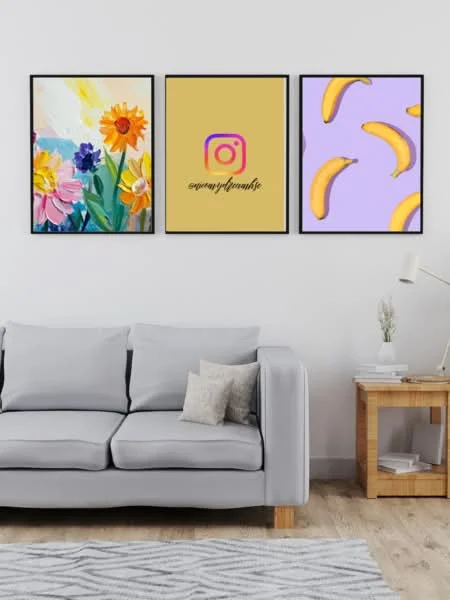 Living features: light grey fabric sofa, wooden coffee table, framed artwork with floral patterns, framed artwork with Instagram logo, framed artwork with banana pattern, wooden flooring, white painted walls, decorative plant on table; style: modern.