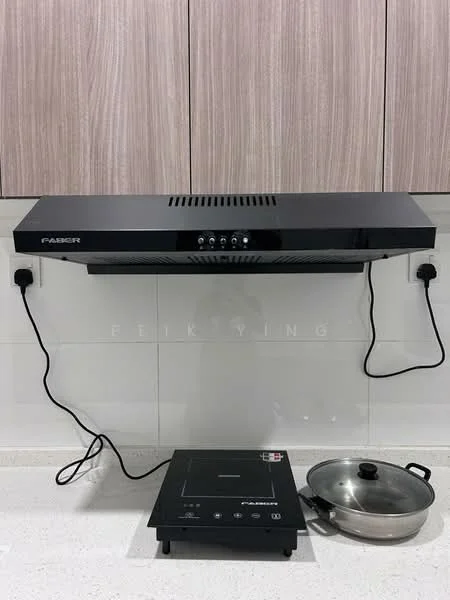 Kitchen features: black range hood, induction cooktop, stainless-steel pot, white tiled backsplash, light-colored countertop, wood cabinetry, electrical outlets visible; style: modern.