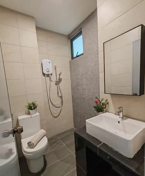 Bathroom features: white ceramic toilet, chrome basin mixer faucet, square white sink, black countertop, shower with handheld showerhead, wall-mounted shower heater, grey tiled walls, dark grey floor tiles, framed mirror, small decorative plants; style: modern.