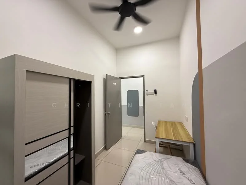 Bedroom features: light grey painted walls, white ceiling, ceiling fan, built-in wardrobe with grey finish, single bed frame, mattress on bed frame, wooden study table, white chair, tile flooring, door to hallway, window with no visible treatment; style: modern.