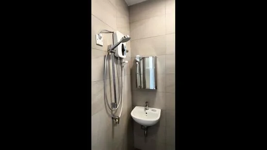 Bathroom features: wall-mounted shower head, handheld shower, chrome faucet, small wall-mounted sink, mirror with frame, beige tiled walls, tile flooring, toilet paper holder; style: modern.
