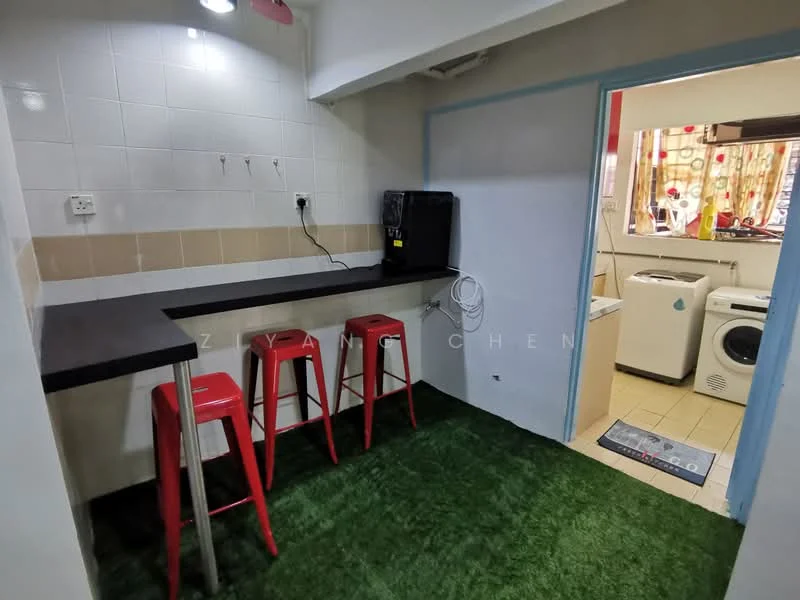 Kitchen features: black countertop, red bar stools, white tiled walls, cream tiled backsplash, green carpet flooring, washing machine, dryer, window with patterned curtains, under-cabinet lighting; style: modern.