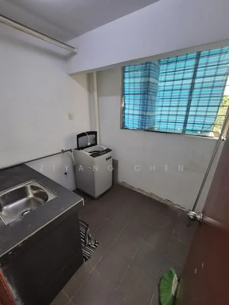 Laundry features: single-bowl stainless-steel sink, top-load washing machine, grey tiled flooring, white walls, window with blue striped curtains, countertop, exposed plumbing, door leading to hallway.