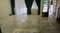 Living features: marble tile flooring, white painted walls, floor-to-ceiling windows, green curtains, sliding glass door, natural light, open layout, decorative columns; style: modern; view: garden.
