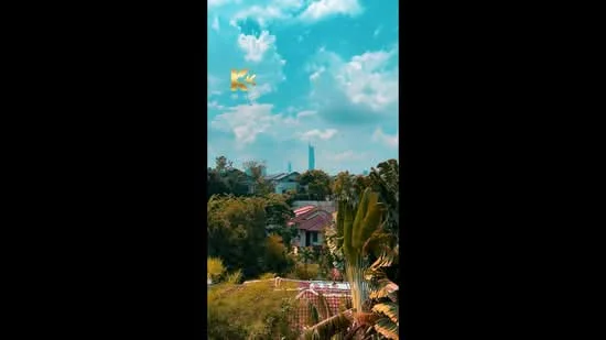 Exterior features: lush greenery, tropical landscaping, city skyline in background, partially visible residential buildings, blue sky with clouds; style: tropical-modern.
