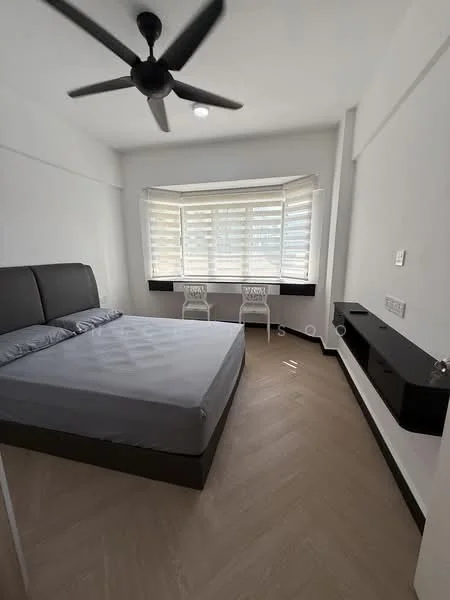 Bedroom features: king-size bed with grey bedding, upholstered headboard, 2 white accent chairs, wooden flooring with herringbone pattern, ceiling fan, window with horizontal blinds, wall-mounted TV console, light fixture on ceiling, neutral painted walls; style: modern.