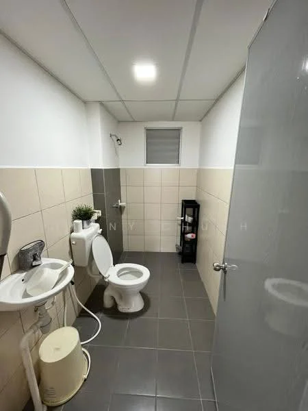 Bathroom features: white toilet, sink with chrome faucet, grey tiled flooring, beige tiled walls, shower area with glass door, small window, black shelving unit, wall-mounted soap dispenser; style: modern.