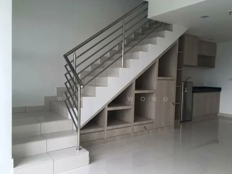 Room features: stainless-steel refrigerator, wood cabinetry, black countertop, white walls, white tiled flooring, staircase with metal railing, built-in shelving under stairs, open space layout; style: modern.