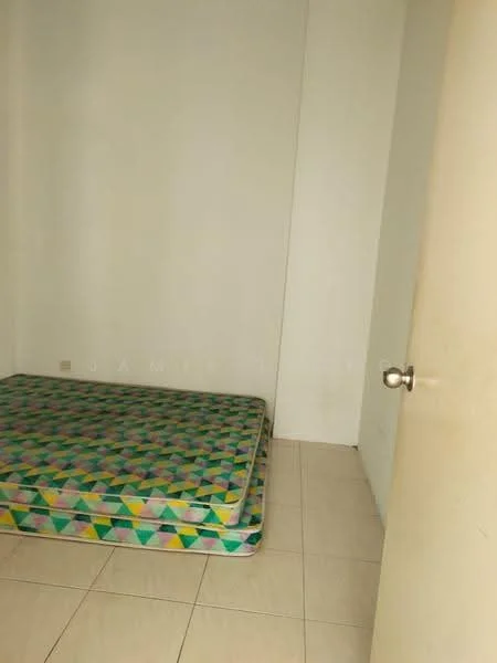 Room features: white painted walls, tile flooring, single mattress on patterned base, door with round knob, empty space.