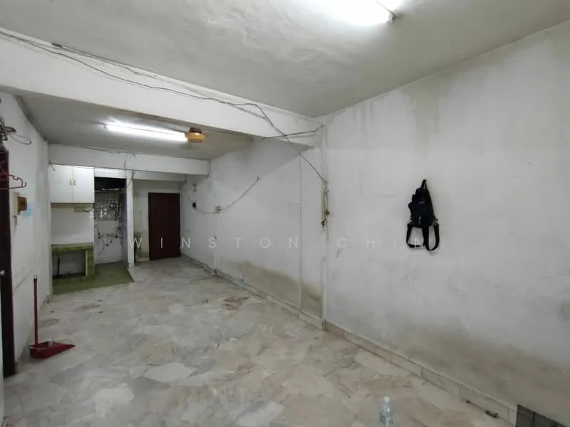 Room features: white painted walls, marble flooring, exposed ceiling with fluorescent lights, visible electrical wiring, doorway leading to another room, cleaning equipment visible, water bottle on the floor.