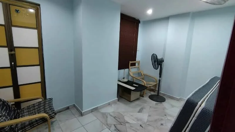 Room features: light blue painted walls, marble tile flooring, ceiling fan, window with brown roller blinds, two wooden chairs, small black coffee table, decorative wall panel with yellow and white sections; style: modern.