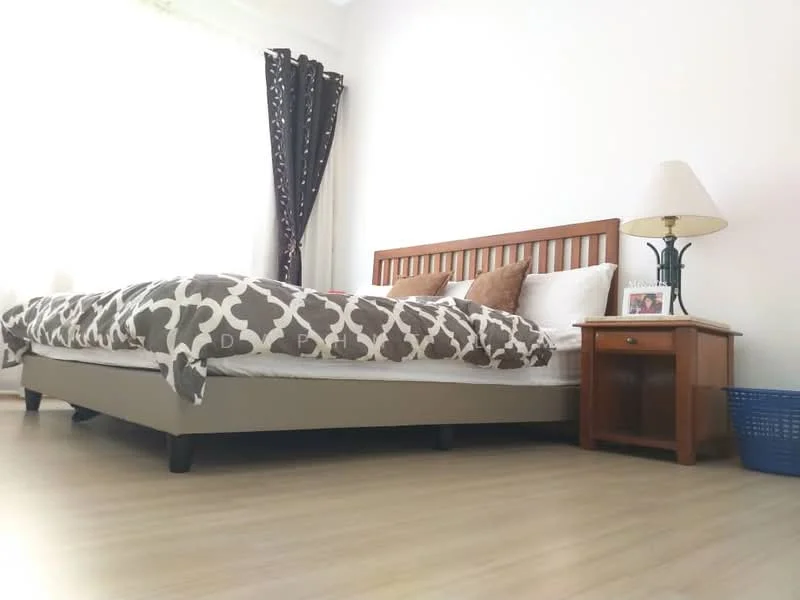 Bedroom features: king-size bed with patterned duvet cover, wooden bed frame, two decorative pillows, nightstand with drawer, table lamp with white shade, light wood flooring, floor-to-ceiling window with sheer curtains, decorative wall art on nightstand; style: modern.