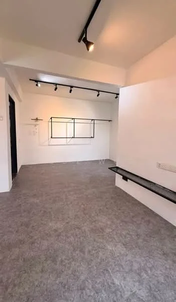 Room features: light grey carpet flooring, white painted walls, track lighting, black metal shelving unit, built-in bench seating, large window with no treatments, open layout, minimalist design; style: minimalist.