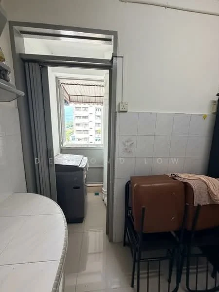 Room features: white tiled walls, white ceramic tile flooring, window with view to outside, washing machine, countertop, stacked chairs, light fixture, doorway leading to another room.