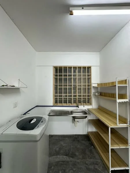 Laundry features: white washing machine, single-bowl stainless-steel sink, wooden shelving unit, grey tile flooring, white painted walls, window with metal grille, overhead fluorescent lighting.