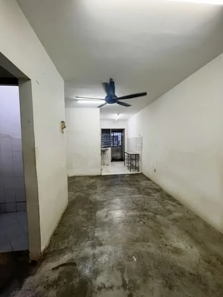 Room features: white painted walls, concrete flooring, ceiling fan, fluorescent lighting, open layout, window with metal grille, doorway leading to another room, unfinished appearance; style: minimalist.
