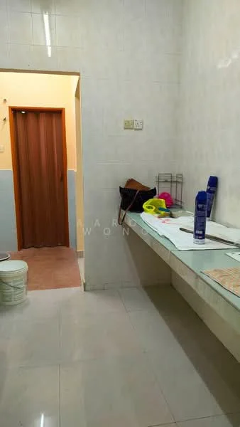 Laundry features: white tiled walls, cream tiled flooring, long countertop, shelf unit, washing machine, bucket, cleaning supplies, doorway to another room.