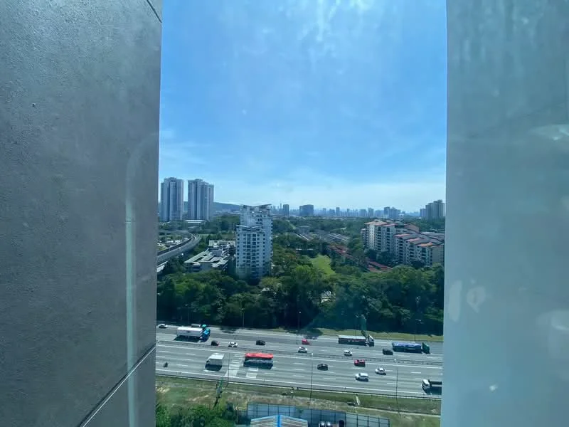 Exterior type: high-rise condominium; features: city skyline view, surrounded by greenery, highway visible, multiple high-rise buildings in background, urban landscape; style: modern.