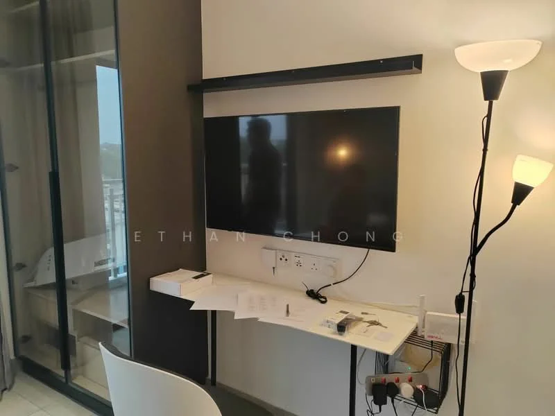 Room features: wall-mounted TV, white wall, light-colored flooring, desk with drawers, electrical outlets, floor-to-ceiling windows, table lamp, modern lighting, minimalist decor; style: modern.