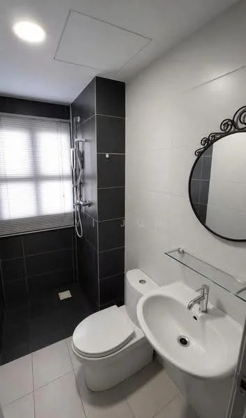 Bathroom features: white ceramic sink, chrome basin mixer, round mirror, one-piece toilet, walk-in shower with glass enclosure, rain shower head, handheld shower, grey tiled walls, white tiled flooring, window with blinds, glass shelf; style: modern.
