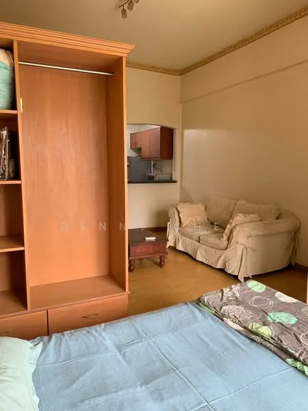 Room features: wooden flooring, cream painted walls, built-in wardrobe with open shelving, sofa in beige fabric, small wooden side table, bed with blue bedding, decorative throw pillows, crown moulding on ceiling; style: modern.