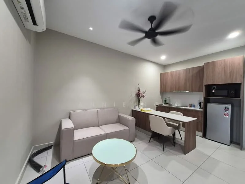 Living features: 3-seater fabric sofa in light grey, round glass coffee table with gold base, wall-mounted split AC, ceiling fan with 3 blades, recessed LED downlights, kitchenette with wood cabinetry, stainless-steel fridge, built-in microwave, kettle, dining table for 2 with white chairs, white tiled flooring, light grey painted walls; style: modern.