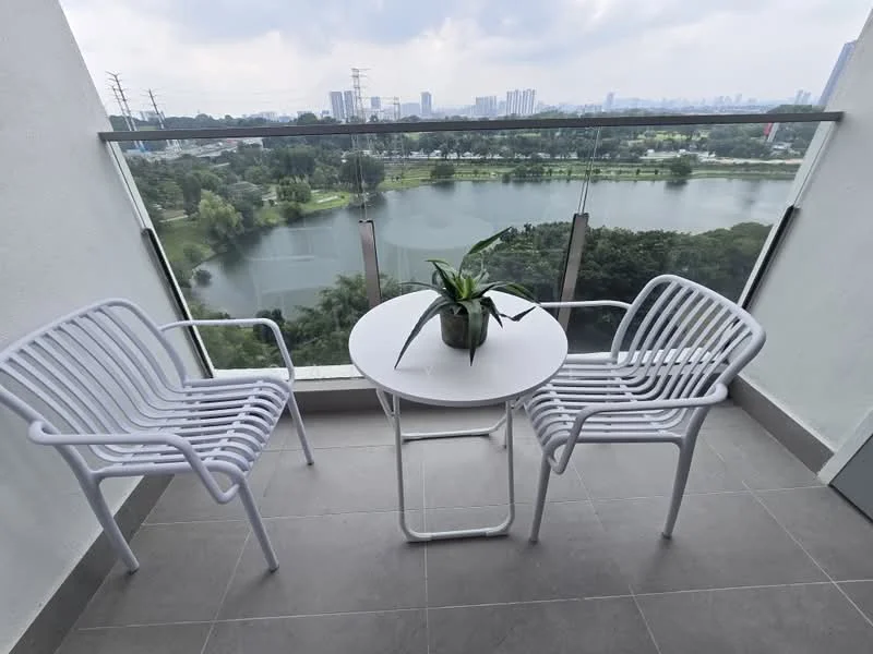 Balcony features: two white metal chairs, round white table, potted plant on table, glass railing, grey tiled flooring, view of lake, view of city skyline; style: modern; view: lake.