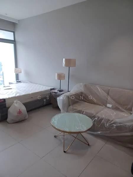 Living features: light grey painted walls, large window with city view, floor-to-ceiling window, beige fabric sofa, coffee table with glass top and gold legs, two bedside lamps with fabric shades, queen-size bed with mattress, tile flooring, decorative throw pillows, plastic covering on furniture; style: modern; view: city.