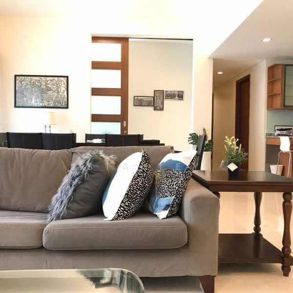 Living features: 3-seater fabric sofa in grey, decorative throw pillows in various patterns, glass coffee table, wooden side table, framed artwork on wall, recessed lighting, cream painted walls, tile flooring, open layout to dining area; style: modern.