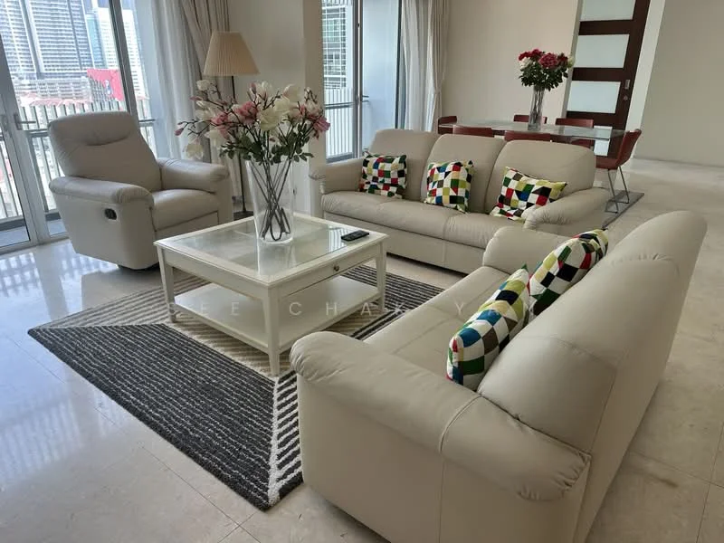 Living features: beige leather sofa, 3-seater sofa, 2-seater sofa, colorful patterned throw pillows, coffee table with glass top, area rug with geometric pattern, recliner chair, floor-to-ceiling windows, curtains, decorative flowers in vase, dining table with chairs in background; style: modern; view: city.