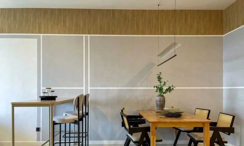 Dining features: wood dining table, black dining chairs, bar-height table, stools, decorative vase with greenery, wall with textured wallpaper, white painted walls with accent lines, pendant light fixture; style: modern.