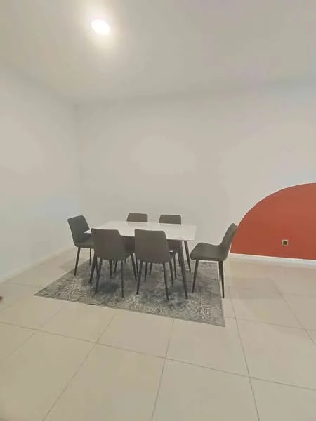 Dining features: white dining table, 6 upholstered dining chairs in grey, area rug with geometric pattern, cream tiled flooring, white painted walls, accent wall in red, recessed ceiling lights; style: modern.