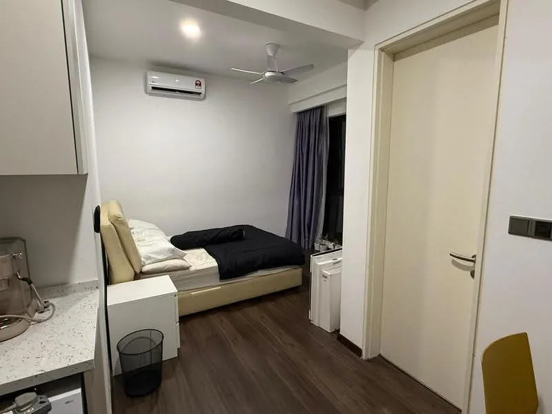 Bedroom features: single bed with beige headboard, black bedding, white walls, wooden flooring, 1 wall-mounted split AC, 5-blade ceiling fan, curtains, nightstand, small waste bin, built-in wardrobe, window with view; style: modern.
