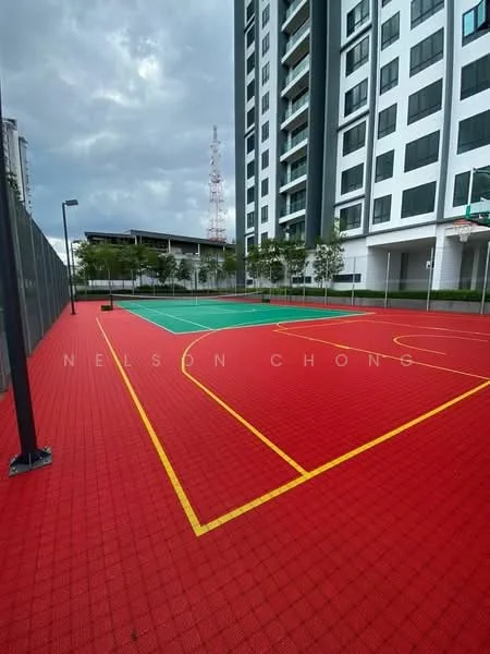 Exterior type: high-rise condominium; features: red sports court flooring, green basketball court, fenced perimeter, outdoor lighting, surrounding landscaping with trees, adjacent building facade, basketball hoop, multi-sport court layout; style: modern.
