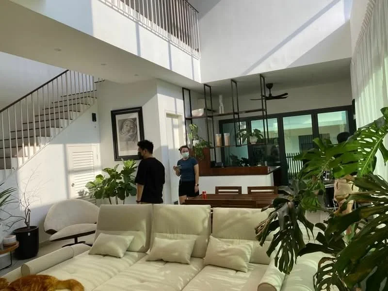 Living features: sofa with cream upholstery, coffee table, floor-to-ceiling windows, wooden dining table, ceiling fan, indoor plants, staircase with white railing, artwork on wall, light streaming through windows, open layout, wooden flooring; style: modern; view: garden.