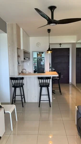 Kitchen features: white cabinets, wooden countertop, black bar stools, pendant light, 5-blade ceiling fan, stainless-steel fridge, wall-mounted clock, tile flooring, open layout, kitchen island; style: modern. Living features: grey sofa, mirror wall, decorative cross, open space, natural light; style: modern.