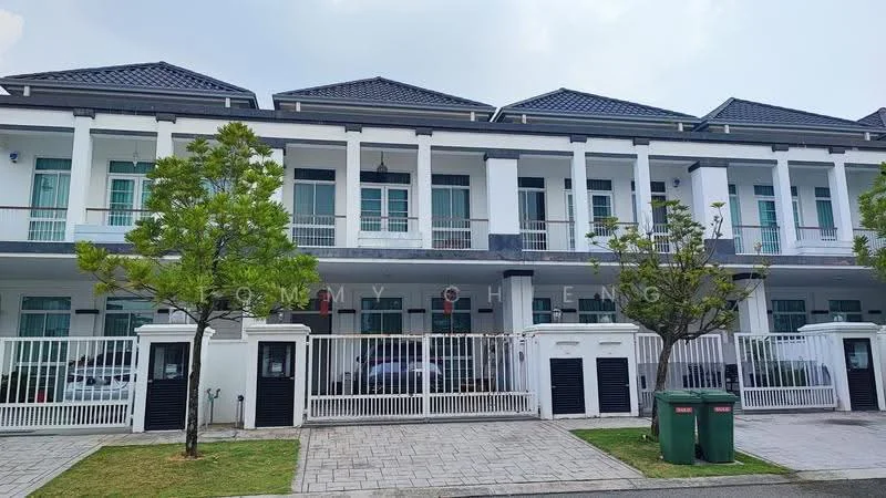 Exterior type: linked terrace house; features: white painted facade, black tiled roof, recessed balconies, manicured lawn, paved walkway, fenced front yard, two trees in front, two green garbage bins, multiple car parking spaces visible, front entrance gates; style: modern.