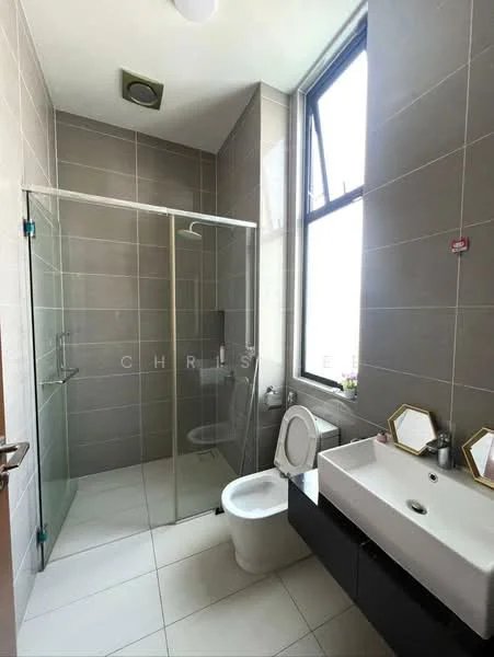Bathroom features: glass shower enclosure, rain shower head, wall-mounted faucet, single-sink vanity with cabinet, white ceramic toilet, large window for natural light, grey tiled walls, white tiled flooring, mirror with geometric frame; style: modern.