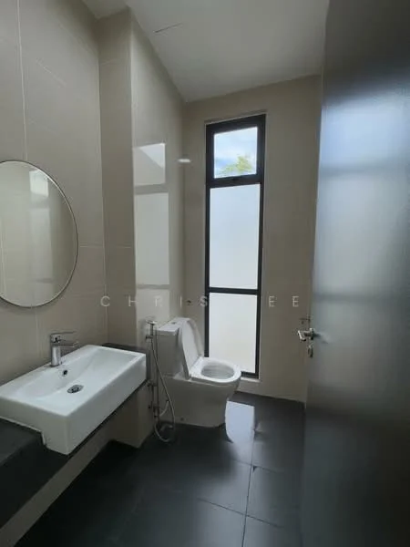 Bathroom features: white ceramic toilet, single-sink vanity with rectangular basin, chrome basin mixer faucet, large round mirror, grey tile flooring, light beige wall tiles, glass window for natural light, shower hose with wall-mounted holder; style: modern.