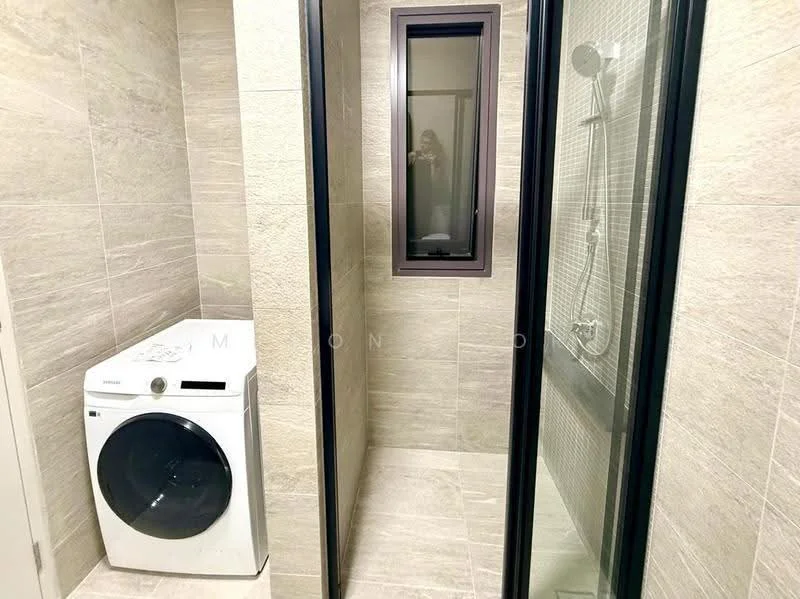 Laundry features: front-load washing machine, grey tiled walls, light grey tiled flooring, glass shower enclosure, shower with handheld shower head, small window, black framed glass door, built-in shelving; style: modern.