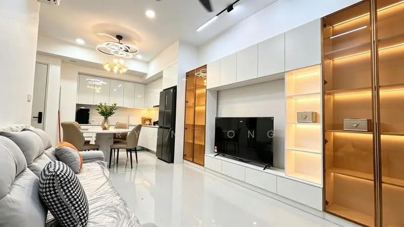Living features: grey fabric sofa, decorative cushions, wall-mounted TV, white built-in cabinetry, gold accent lighting, recessed ceiling lights, marble tile flooring, open-plan layout to kitchen, decorative wall paneling, dining area visible in background; style: modern. Kitchen features: white cabinetry, black refrigerator, stainless-steel appliances, kitchen island with seating, pendant lighting, ceramic tile backsplash, open shelving, marble countertop; style: modern.