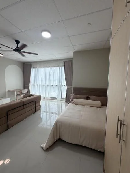 Bedroom features: king-size bed with beige bedding, upholstered headboard, 2-seater fabric sofa in beige, white sheer curtains, ceiling fan with light, built-in wardrobe with wooden finish, glossy tile flooring, recessed ceiling lights, study table, decorative wall arch; style: modern.