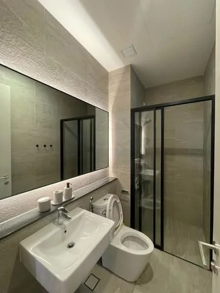 Bathroom features: single-sink vanity with white cabinet, chrome basin mixer faucet, large framed mirror, one-piece toilet, walk-in shower with glass enclosure, tile cladding on walls, light-colored tile flooring, recessed ceiling lights; style: modern.