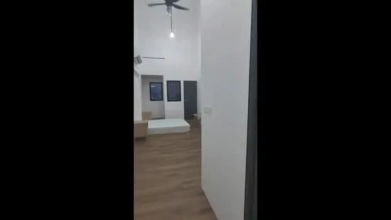Room features: light wood flooring, white painted walls, ceiling fan, recessed lighting, window with black frame, open space layout, unmade bed, minimalist decor; style: modern.