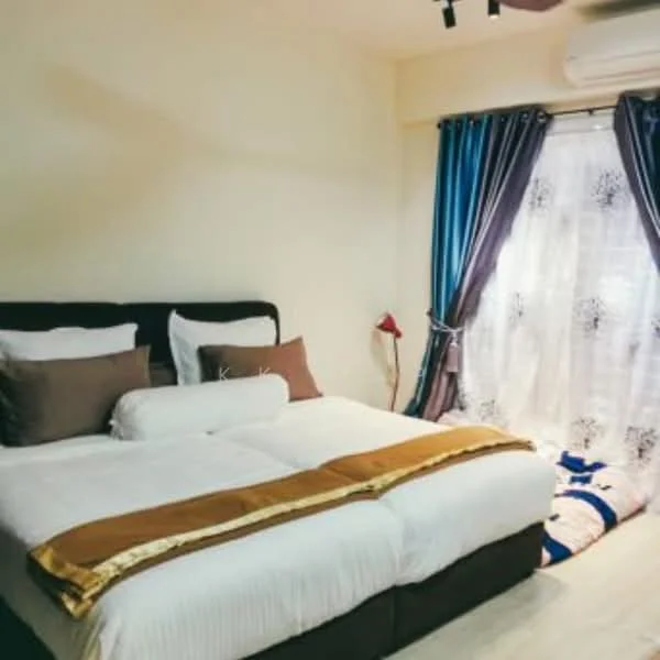 Bedroom features: king-size bed, upholstered headboard, white bedding, decorative pillows, bedside lamp, curtains with blue and brown tones, floor-to-ceiling window, air conditioning unit, light wood flooring, neutral painted walls; style: modern.