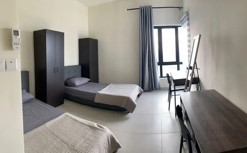 Bedroom features: two single beds with grey bedding, dark wood wardrobe, large window with sheer curtains, grey curtains, wooden dining table, four black dining chairs, light-coloured tiled flooring, mirror on easel; style: modern.