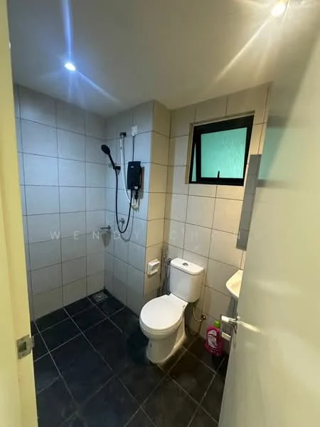 Bathroom features: grey tiled walls, black tiled flooring, one-piece toilet, handheld shower, wall-mounted shower head, sink with faucet, small window, mirror above sink, toilet paper holder, shower area with glass partition; style: modern.