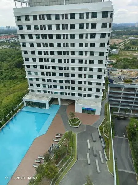 Exterior type: high-rise condominium; features: infinity pool, pool deck with loungers, landscaped garden area, paved walkway, multi-storey car park, surrounded by greenery, modern facade with large windows, balconies on upper floors; style: modern.
